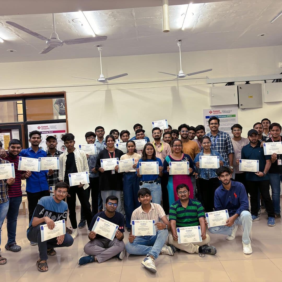 Vedant Bhavsar with a group of students holding certificates, celebrating the successful completion of a workshop on generative AI and web development, held at Ganpat University. 1